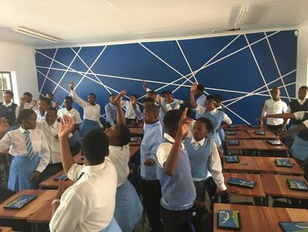 Learners raising their hands in a Telkom project classroom