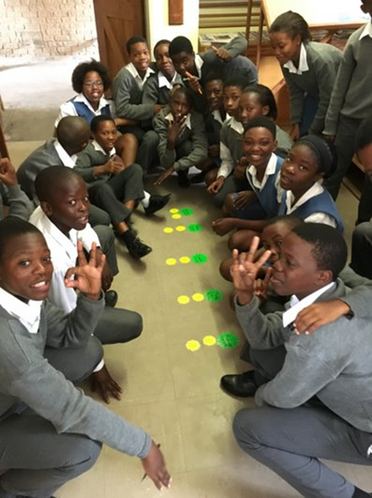 Learners gathered around a floor activity during a workshop