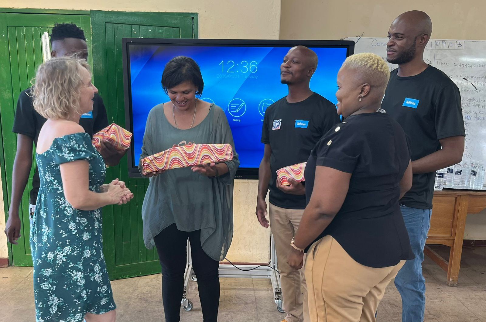 Kutitiva team members presenting gifts to PROTEC staff